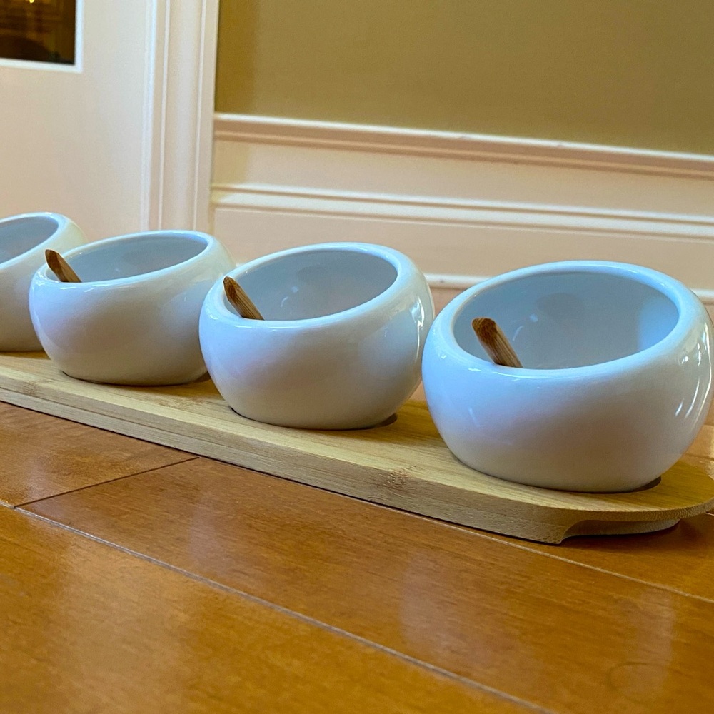 Set of four condiment bowls with spoons and bamboo stand